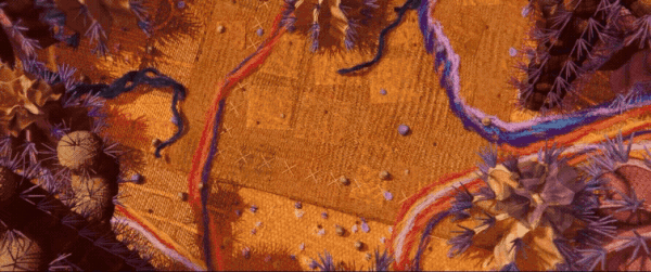 a gif from an animated film called "Au 8ème Jour" showing a textile-like landscape from above with black yarn leeching into it