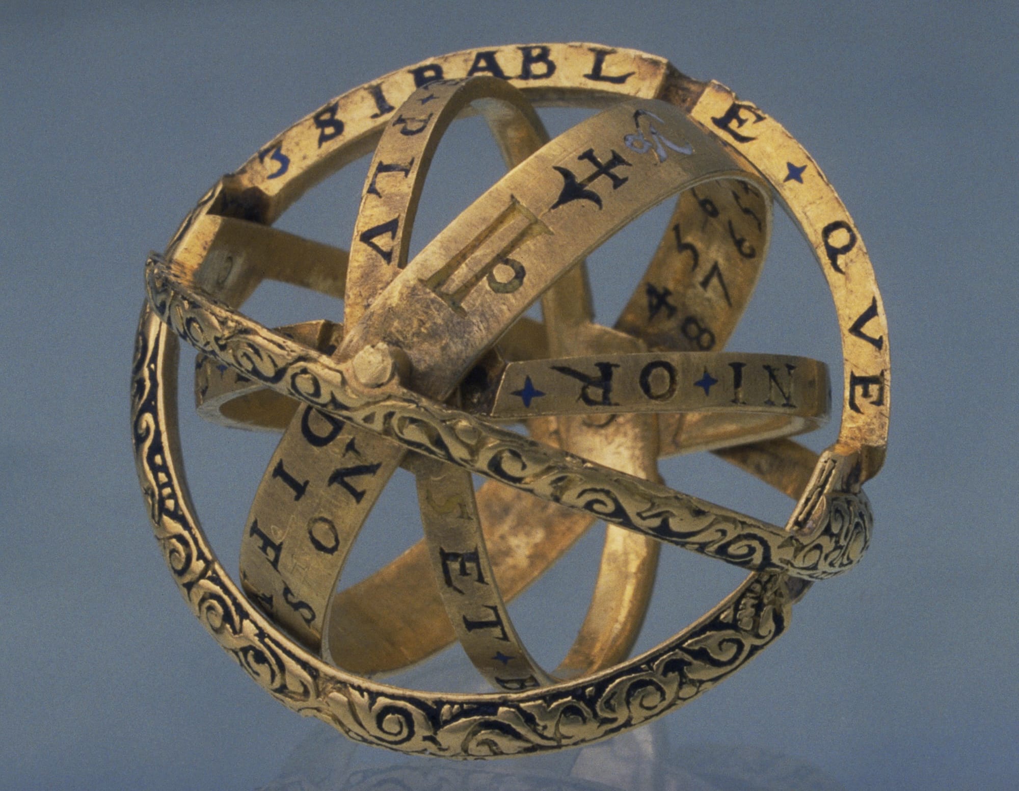 a photo of an armillary ring with engraved symbols and Zodiac signs