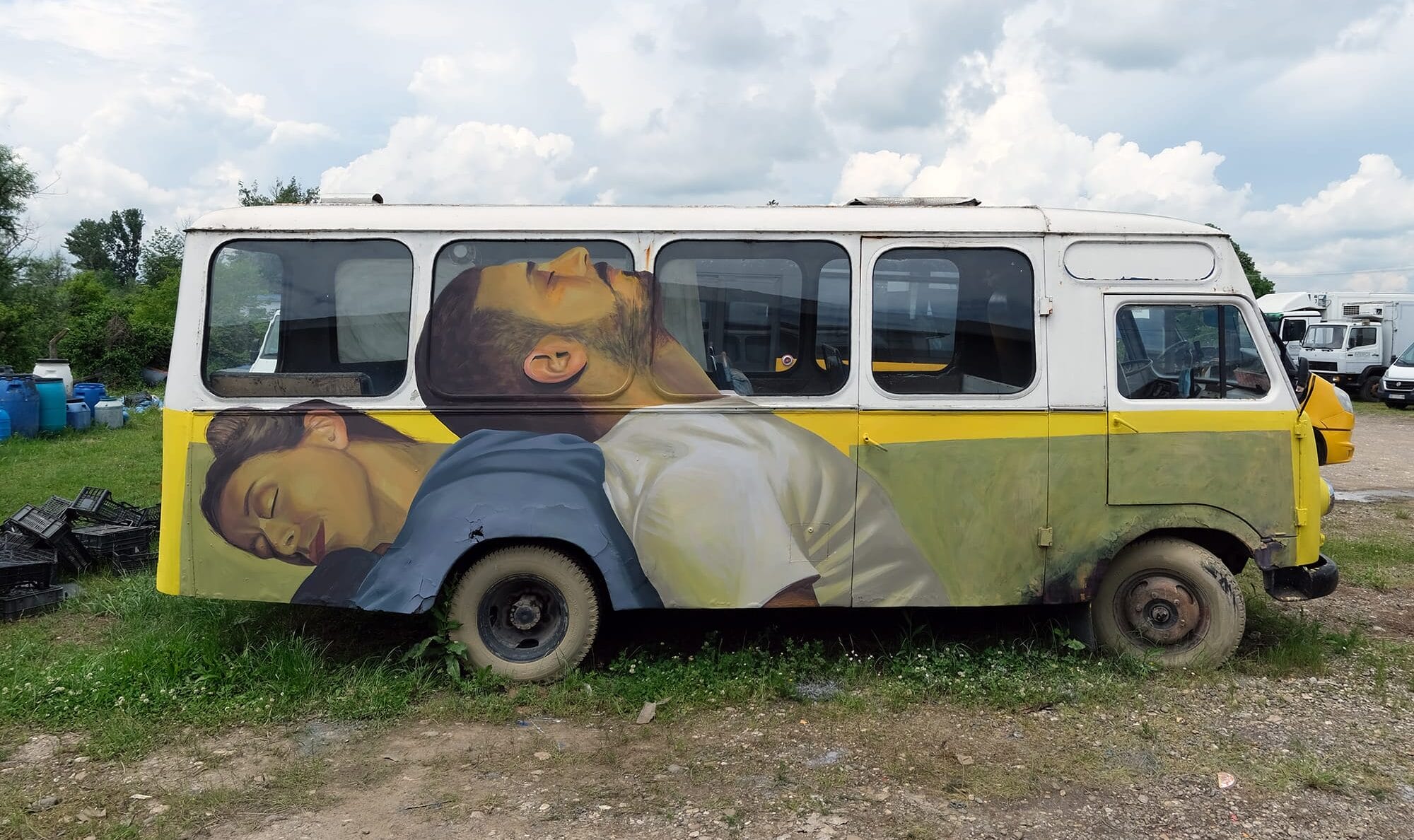 a mural on the side of a small bus showing two men sleeping