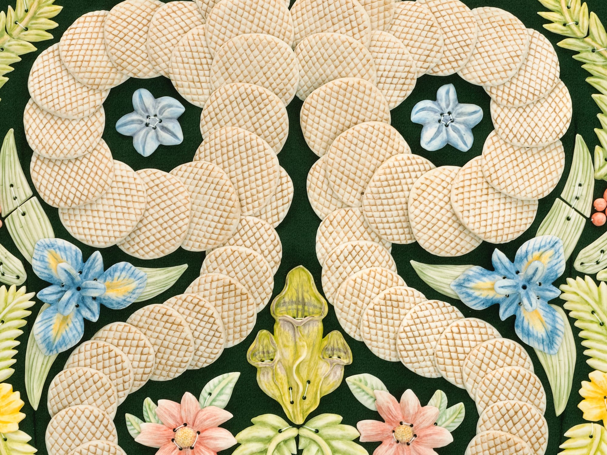 a detail image of a vest by Shae Bishop covered in two snakes and florals, all depicted in tile