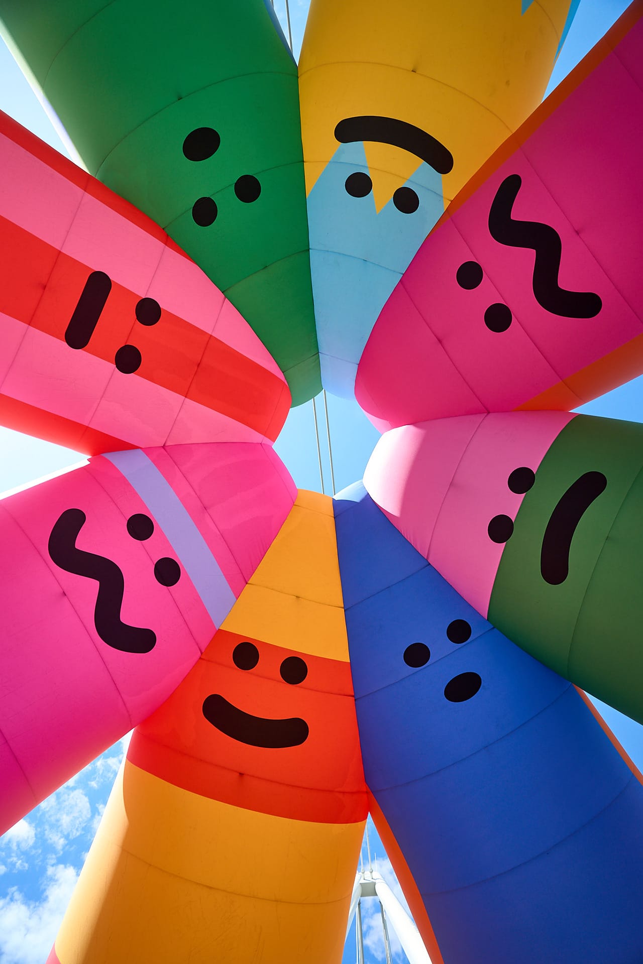 the underside of a colorful, inflatable installation by Craig & Karl of crayon-like shapes with expressive faces