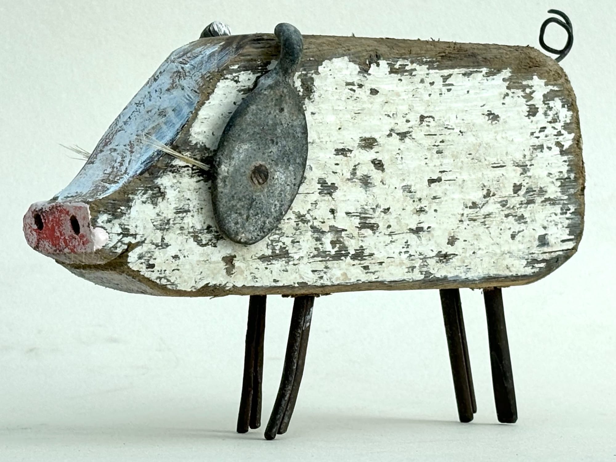 a pig sculpture made of worn white wood