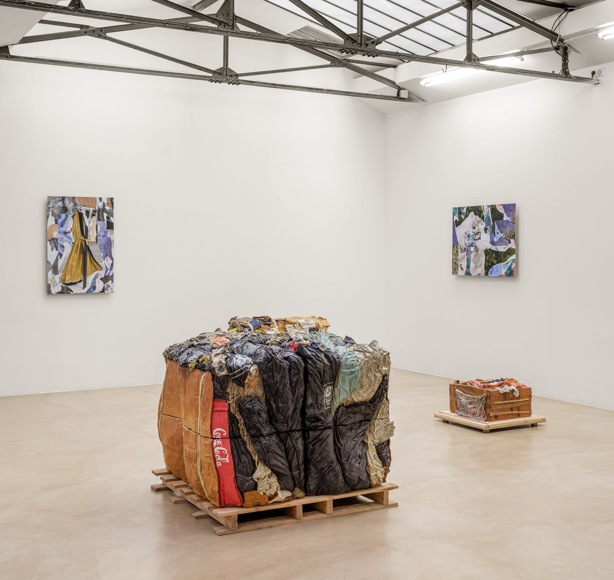 an installation view of an exhibition by Ninon Hivert of glass, bronze, and clay sculpture mimicking stacks of discarded materials like cardboard and clothing