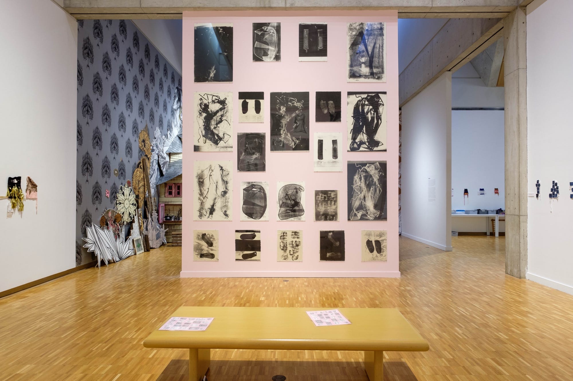 a pink wall with monoprints and small weavings by Bryana Bibbsare in the foreground. the pieces are in a gallery at the Haggerty Museum of Art