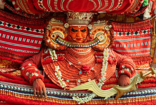 a photograph by Navneet Jayakumar of an elaborate ceremonial outfit worn by a performer for Theyyam, in Kerala, India