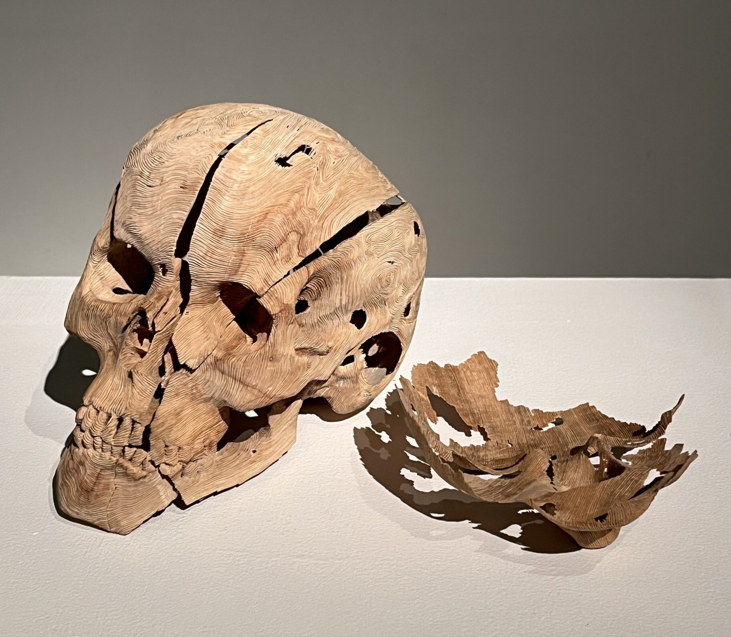a carved wooden sculpture of a skull by Ryo Matsumoto