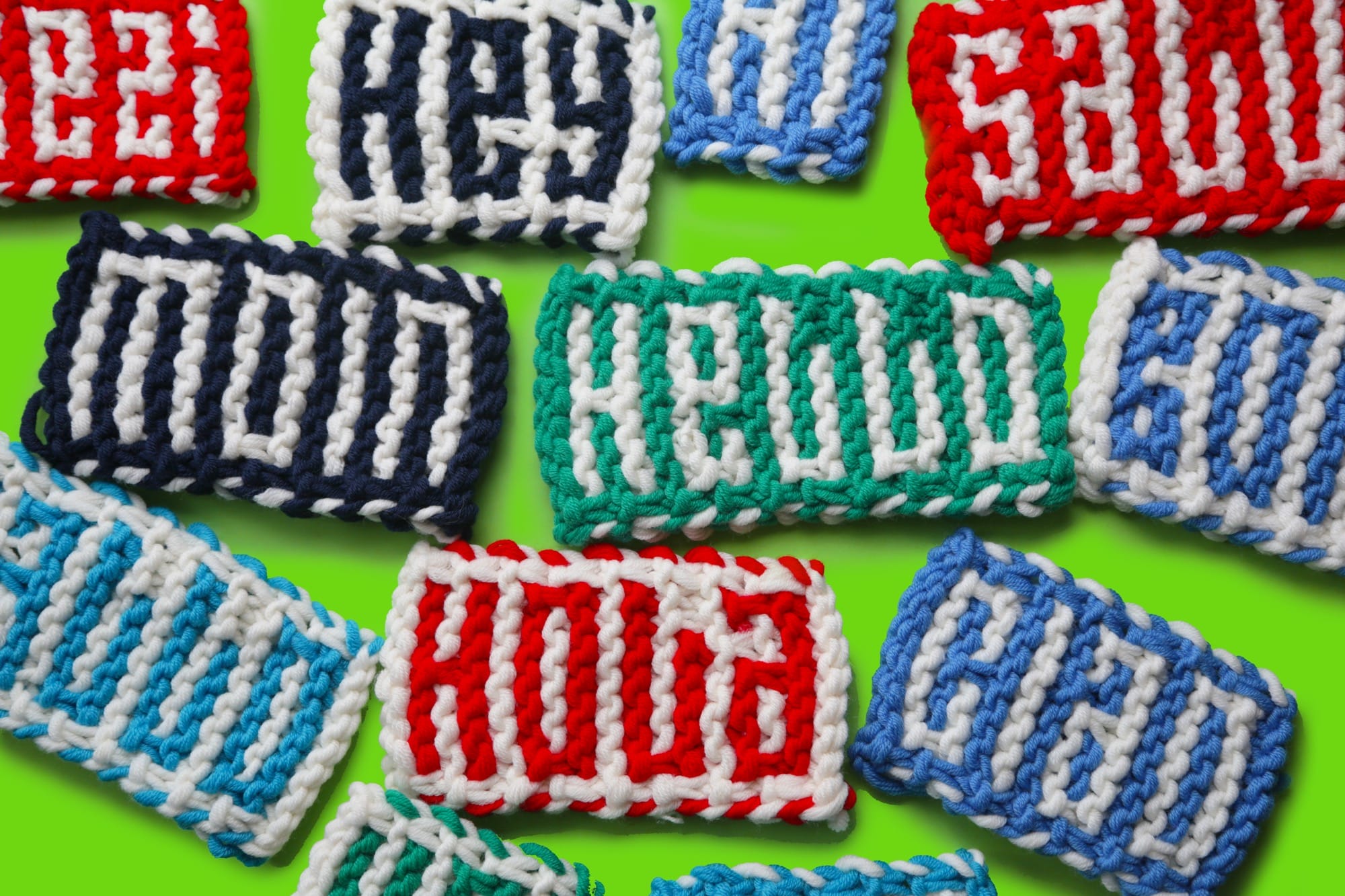 mini knitted fabric pieces that read "HELLO" in different languages