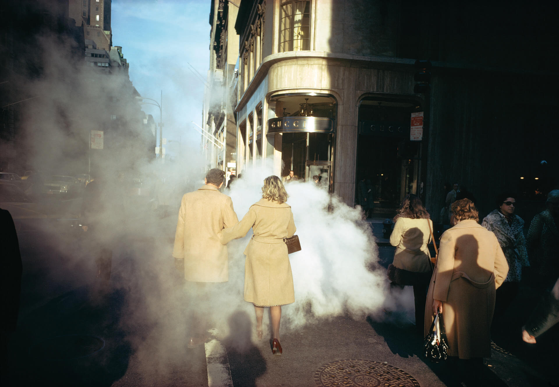 A photo of people walking in Manhattan, wearing camel trench coats, by Joel Meyerowitz