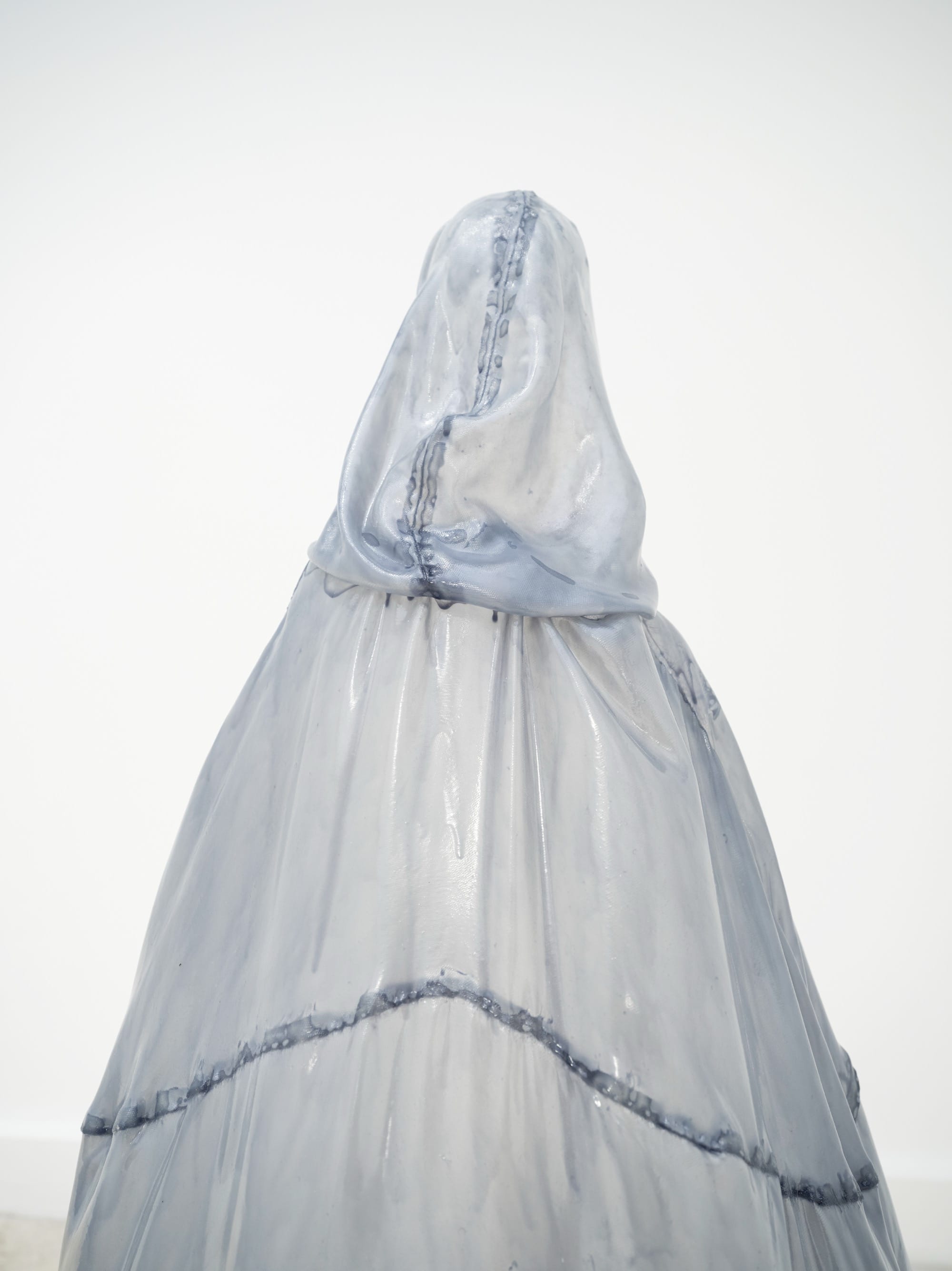 A stiff pale blue fiberglass victorian style dress by Brandon Morris that stand without wearers in the middle of a gallery