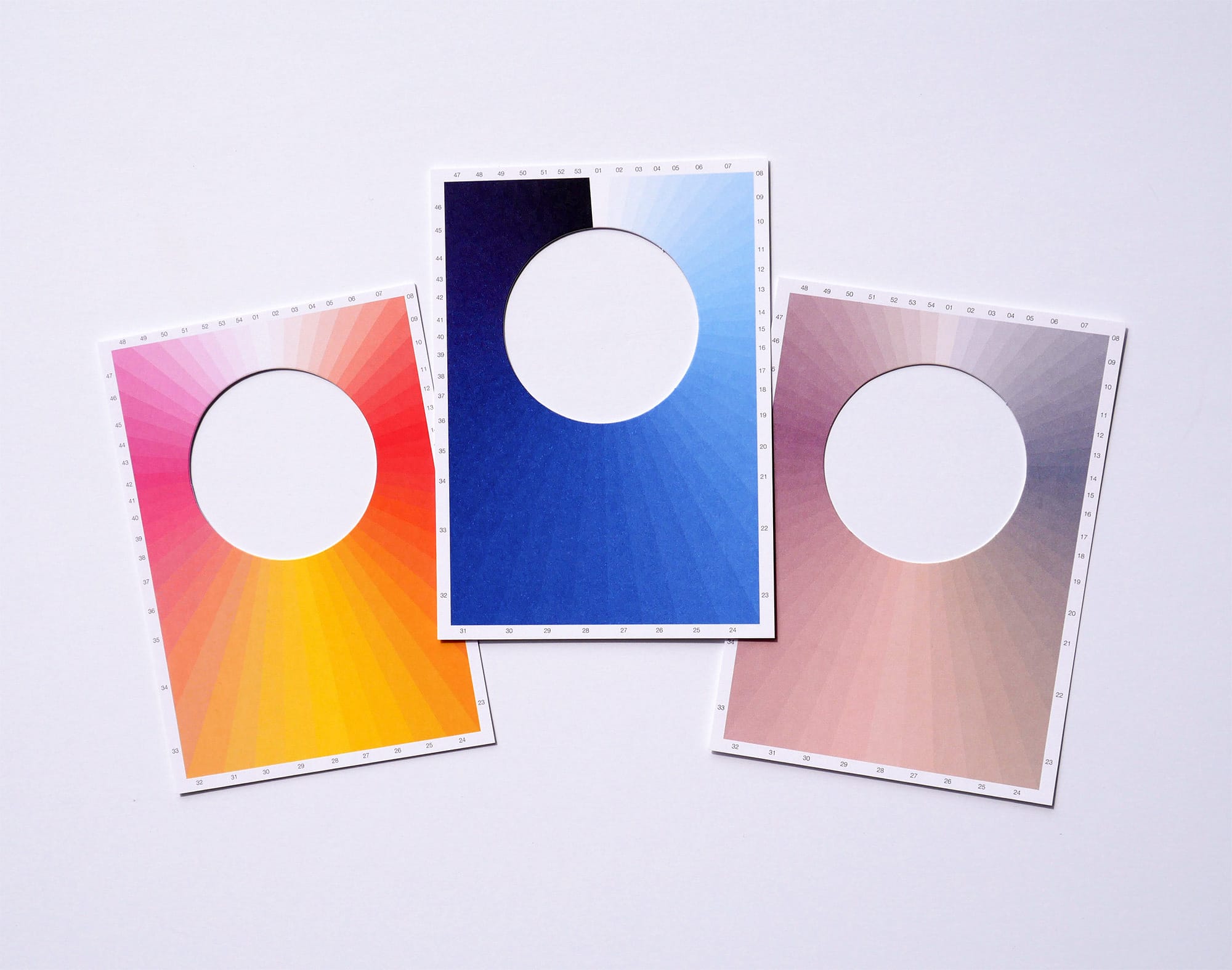 three postcards with holes in the center