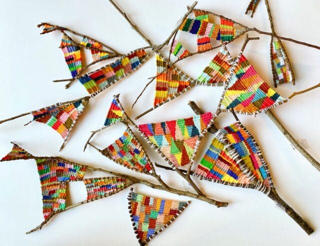 a collection of wish bones with colorful fiber woven between the bones by Kaci Smith