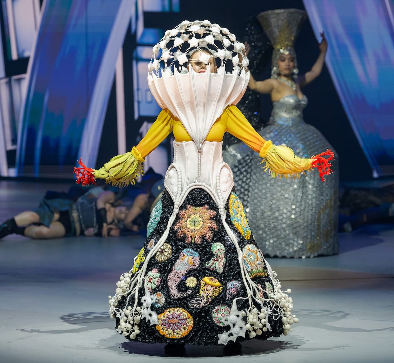 an elaborate costume with a globe-like headpiece, worn by a performer on stage